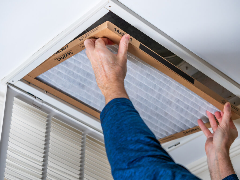 HVAC technician replacing a home air filter in Walnut