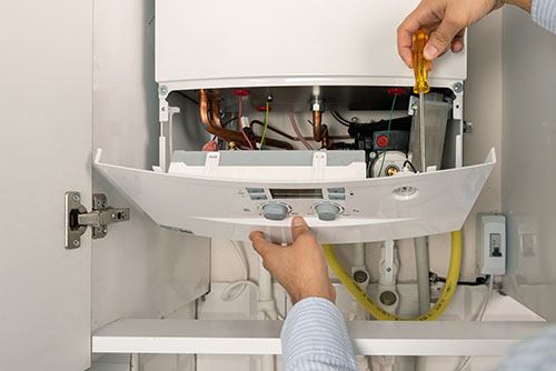 Heating technician repairing a residential boiler in Walnut