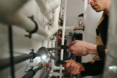 Technician inspecting commercial plumbing pipes in Walnut