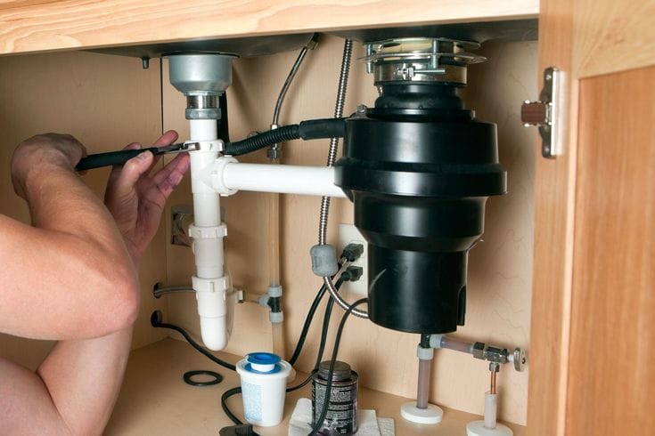 Plumber repairing a garbage disposal in Walnut