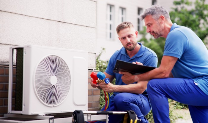 HVAC technicians installing an outdoor air conditioning unit in Walnut