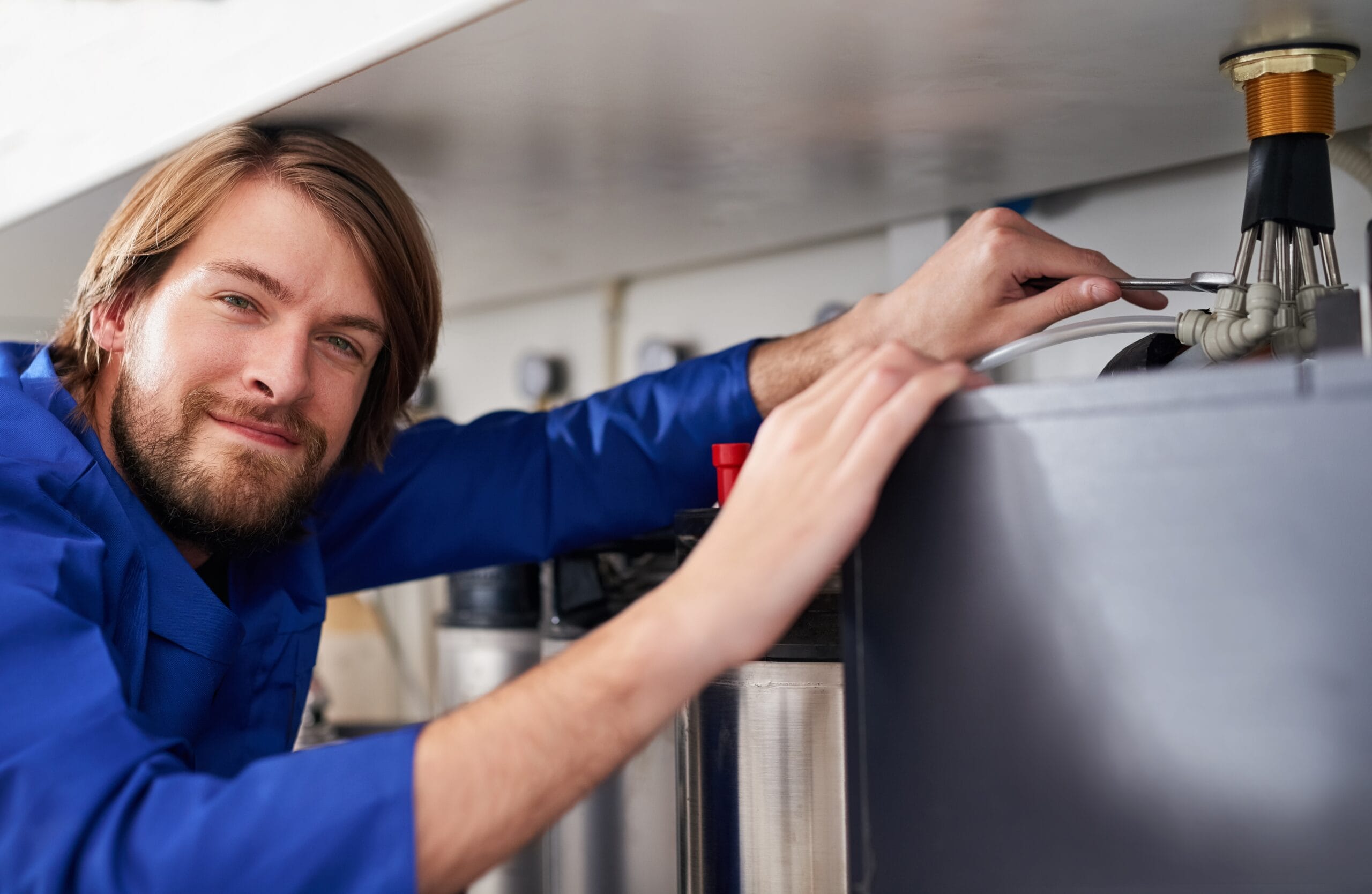 Technician servicing a residential water heater tank in Walnut